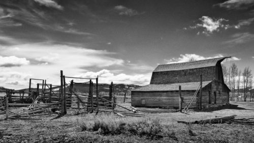 Photo noir et blanc d'un ancien corral à bestiaux typique du farwest et proche d'une grange abandonnée aux éléments © Ron Fross - Beautiful Wyoming