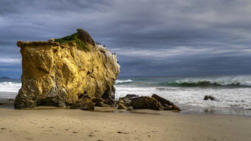 Photo en couleur d'un rocher d'ocre jaune exposé aux vagues et aux embruns du Pacifique © Ron Fross - Grandeur Nature