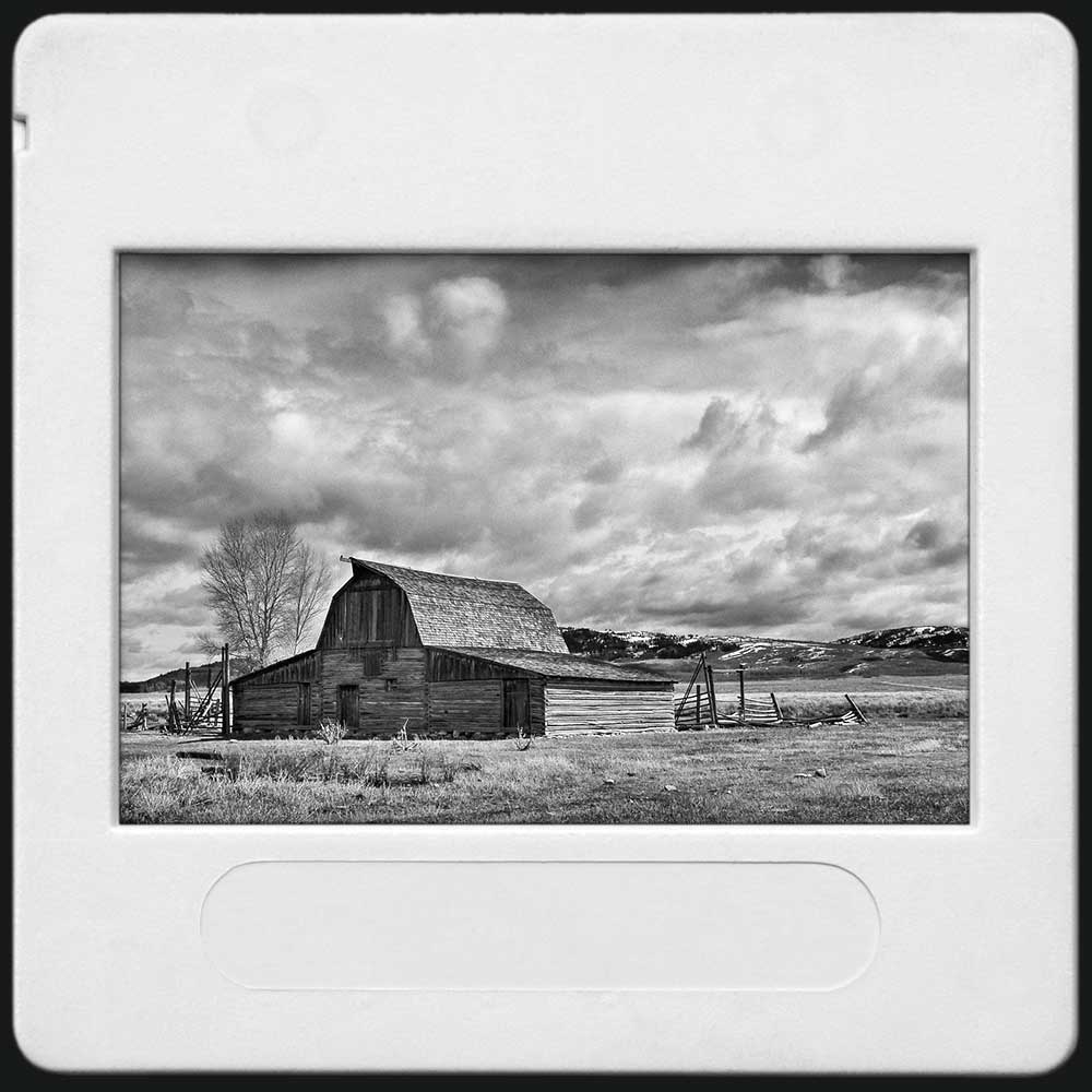 Photo noir et blanc d'une vieille grange centenaire sous un ciel d'hiver dans l'ouest américain