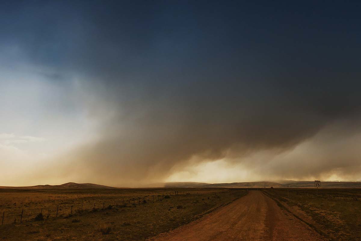 Photo couleur en clair-obscur de nuages tombants sur les champs trop secs © Ron Fross - Beautiful Wyoming