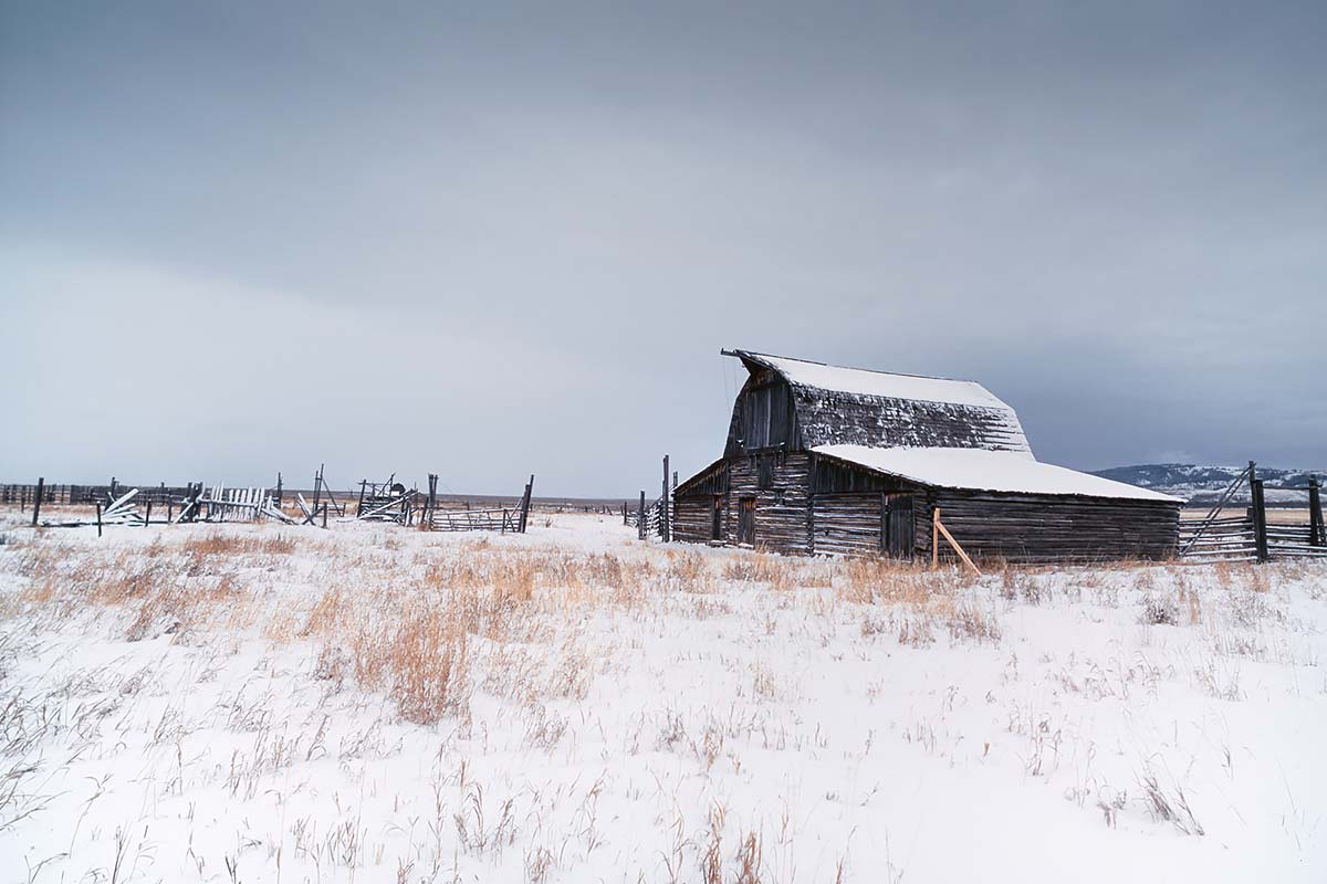 Photo couleur d'une vieille grange sous un ciel de neige à Jackson Hole