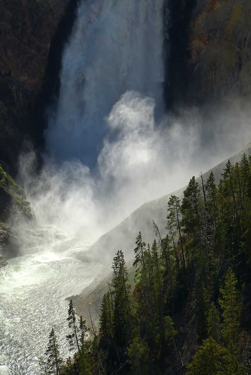 Photo en couleur et clair-obscur des chutes du Yellowstone avec ses embruns qui ajoutent à l'image un côté mystique