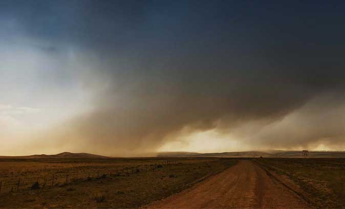 Photo couleur en clair-obscur de nuages tombants sur les champs trop secs